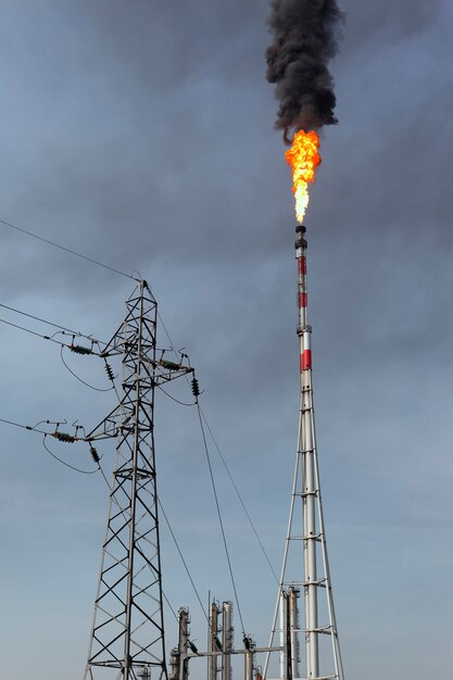 Feuerfackel in der Fabrik über blauem Himmel