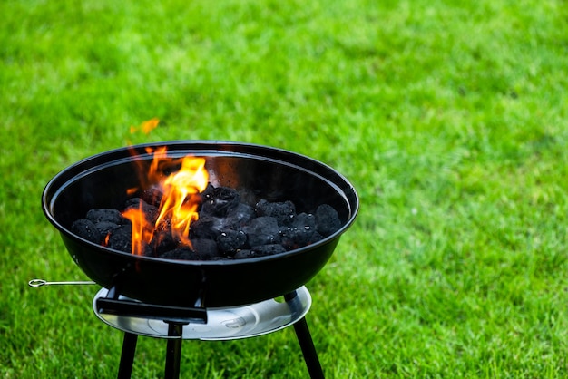 Feuerflammen auf Grillgrill im Garten im Hinterhof