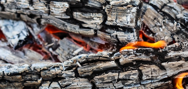 Feuerflammen und heiße Kohlen aus verbranntem Holz