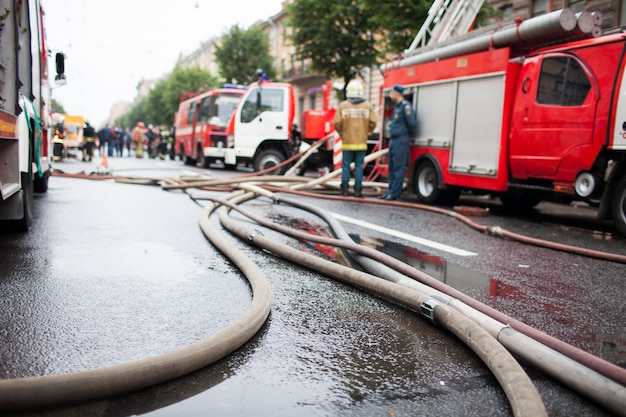 Feuerlöschschläuche auf dem Hintergrund von Feuerwehrautos.