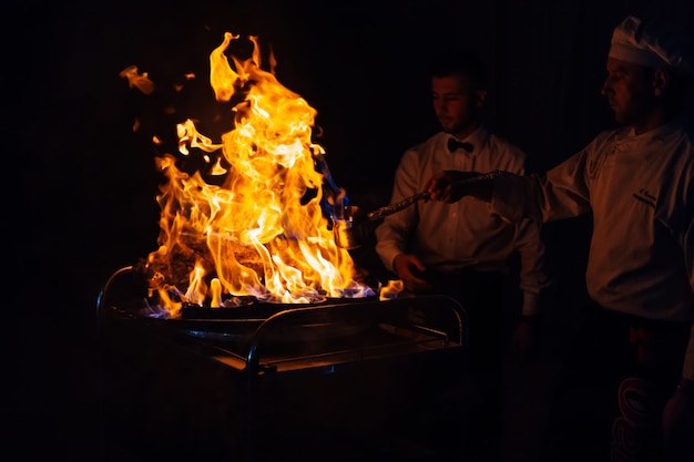 Feuerpräsentation und Kochshow beim Hochzeitsempfang kocht köstliches Fleisch