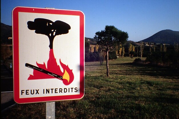 Foto feuerschild mit text auf dem feld gegen klaren blauen himmel