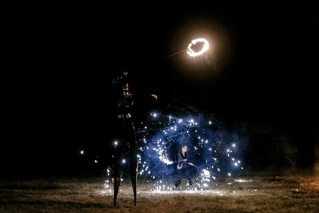 Foto feuershow fakir jongliert mit feuer poi night performance illusion eines schwebenden objekts