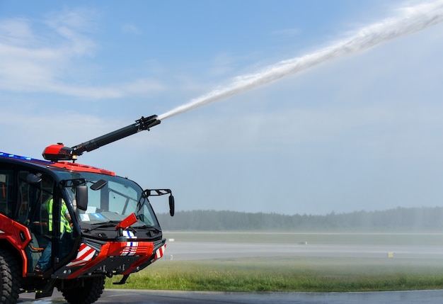 Feuerwehrauto löscht Feuer am Flughafen.