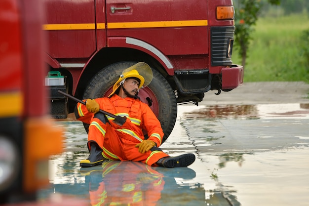 Feuerwehrleute sitzen erschöpft, um sich auszuruhen, nachdem sie den Opfern des Feuers geholfen haben.