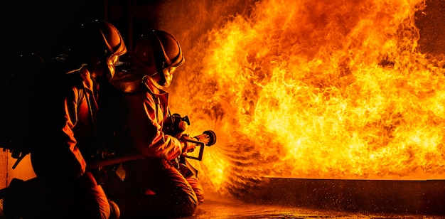 Feuerwehrleute sprühen nachts Flammen nieder