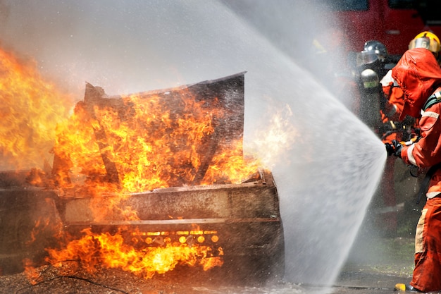 Feuerwehrleute verwenden Feuerlöscher und Wasser für das Feuer der Kämpfer während des Feuerwehrtrainings.