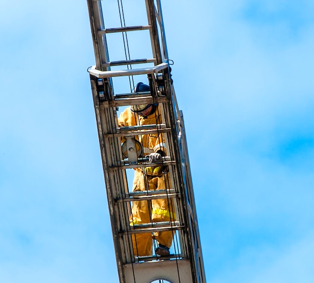 Feuerwehrmann im Training klettert mit der Feuertreppe.