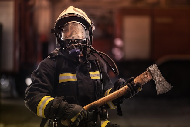 Feuerwehrmann in Schutzkleidung mit Axt