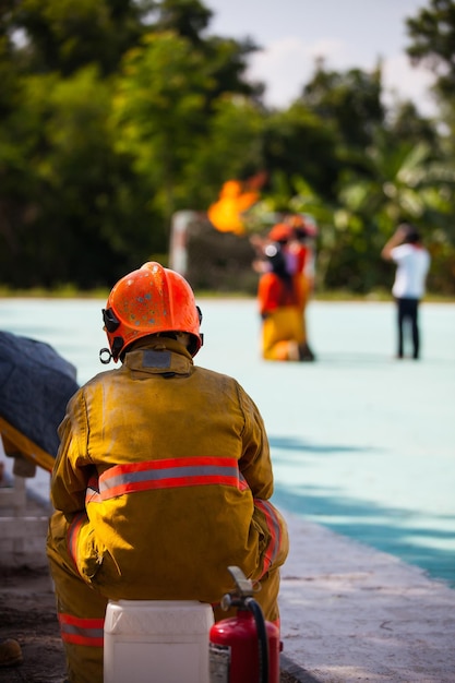 Feuerwehrmann mit Feuer und Anzug zum Schutz des Feuerwehrmanns für die Ausbildung von Feuerwehrleuten