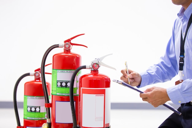 Feuerwehrmann prüft Manometerstand des Feuerlöschers.