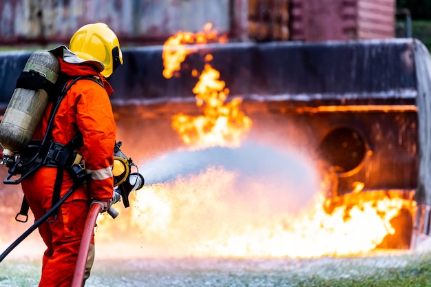 Feuerwehrmann sprüht Feuer von Öltankwagenunfall