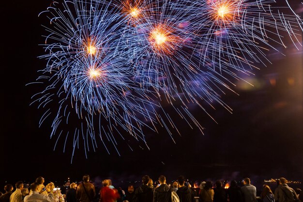 Feuerwerk mit Silhouetten von Menschen bei Feiertagsveranstaltungen