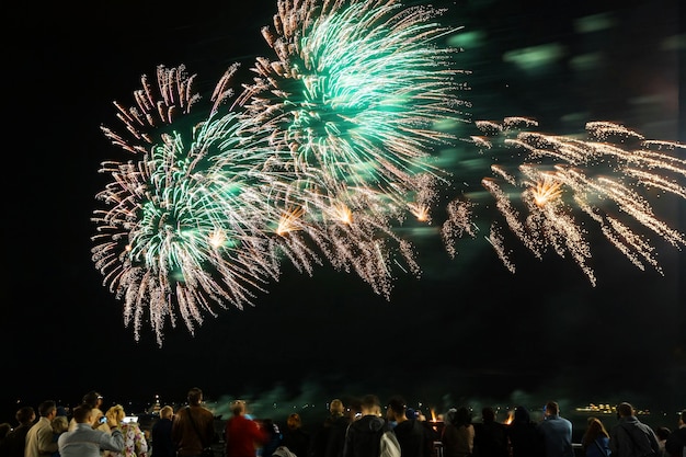 Feuerwerk mit Silhouetten von Menschen bei Feiertagsveranstaltungen