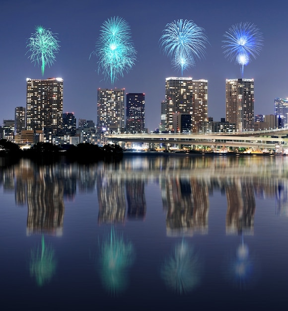 Feuerwerke, die über Tokyo-Stadtbild mit Spiegelreflexion an nahem feiern