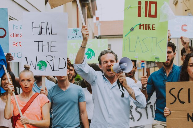 Öffentliche Demonstration auf der Straße gegen globale Erwärmung und Umweltverschmutzung. Gruppe multiethnischer Menschen, die gegen den Klimawandel und plastische Probleme in den Ozeanen protestieren