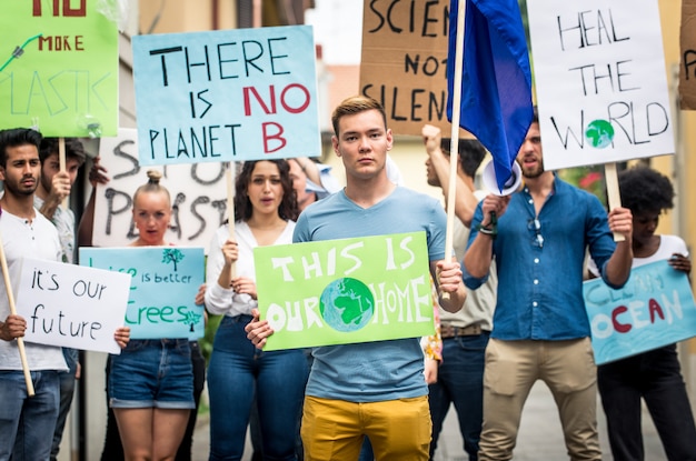 Öffentliche Demonstration auf der Straße gegen globale Erwärmung und Umweltverschmutzung. Gruppe multiethnischer Menschen, die gegen den Klimawandel und plastische Probleme in den Ozeanen protestieren