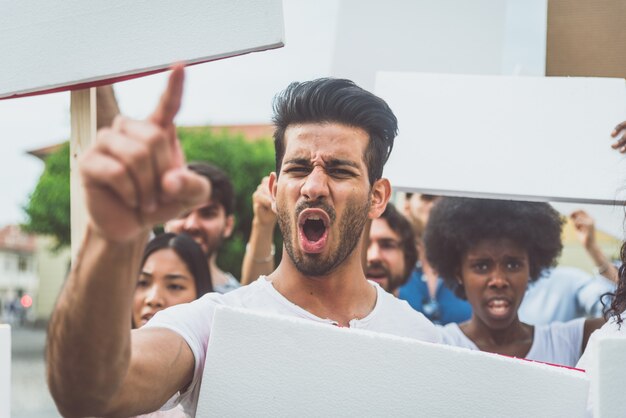 Öffentliche Demonstration auf der Straße gegen soziale Probleme und Menschenrechte. Gruppe multiethnischer Menschen, die öffentlich protestieren