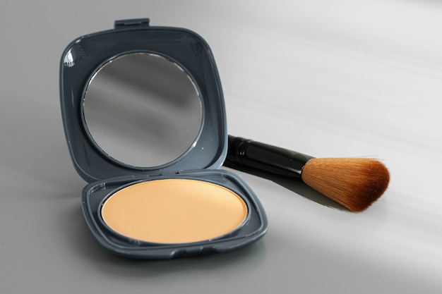 Öffnen Sie die Schachtel mit Make-up-Puder auf Grau