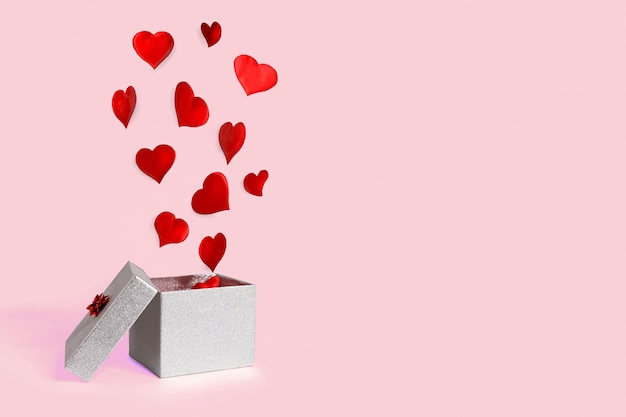 Öffnen Sie die silberne Geschenkbox mit fliegenden Herzen. Levitation. fröhlichen Valentinstag.