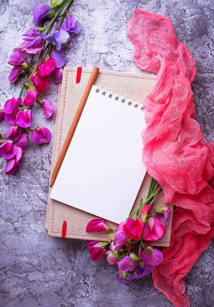 Öffnen Sie leeres Notizbuch und Blumen.