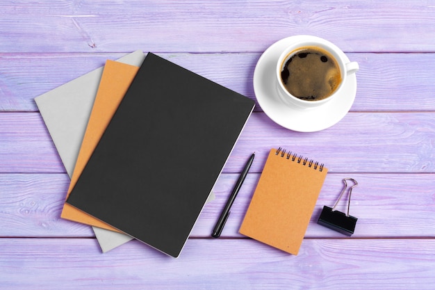 Öffnen Sie Notizbuch mit Tasse Kaffee auf hölzernem Schreibtisch