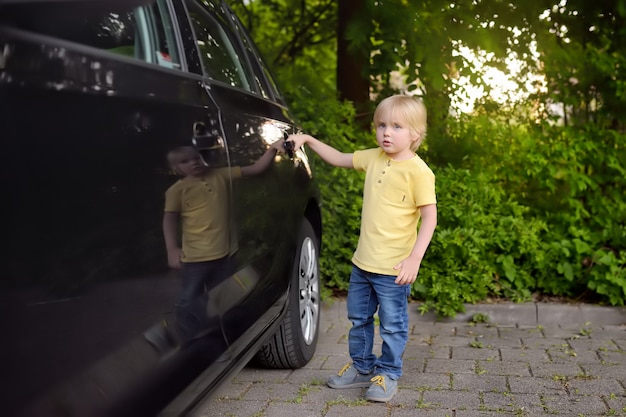 Öffnungstür des kleinen Jungen des Autos.