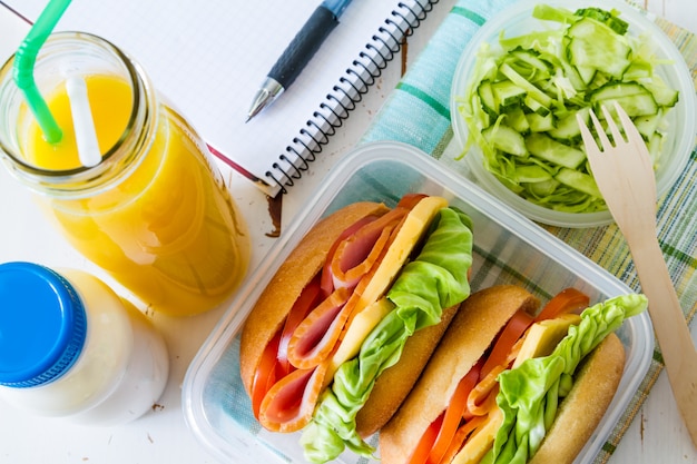 Fiambrera con ensalada de sandwich y friuts.