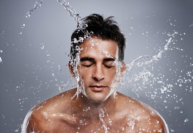 Ficando limpo Um jovem jogando água no rosto