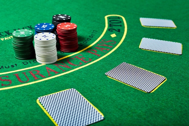 Foto fichas de casino y baraja de cartas en la mesa de casino verde, concepto de juego de póquer.