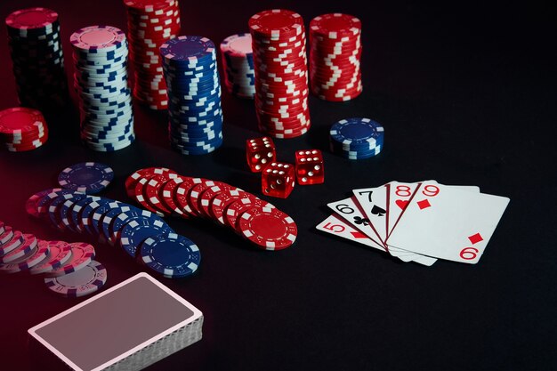 Fichas de casino y cartas sobre la superficie de la mesa negra. Concepto de juego, fortuna, juego y entretenimiento - de cerca. Poker en línea. Copie el espacio. Ideal para publicidad. Naturaleza muerta