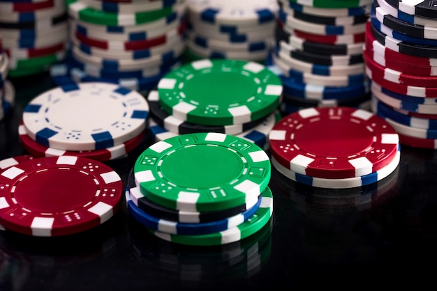 Fichas de casino coloridas en primer plano de superficie oscura
