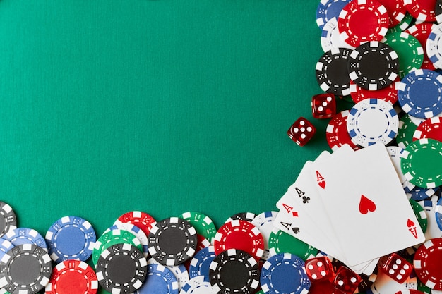Foto fichas de casino jugando a las cartas y dados en la mesa de tela verde