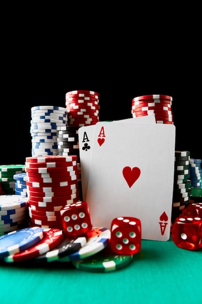 Fichas de casino jugando a las cartas y dados en la mesa de tela verde