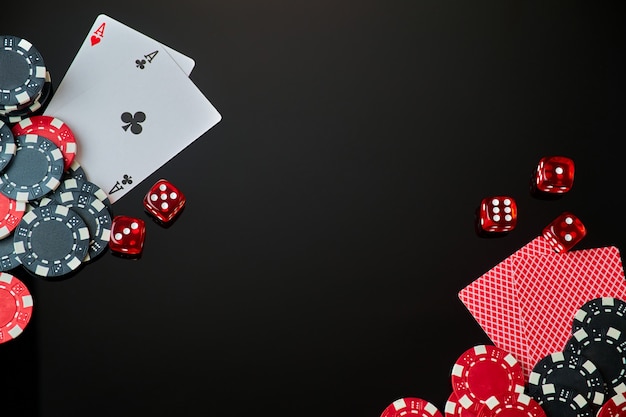 Fichas de casino jugando a las cartas y dados sobre fondo reflectante oscuro