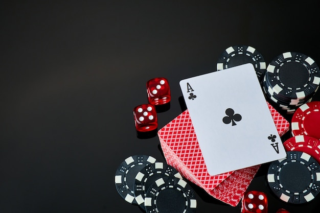 Fichas de casino jugando a las cartas y dados sobre fondo reflectante oscuro