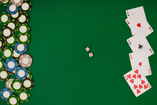 Fichas de cores diferentes para apostas e cartas de jogar sobre fundo verde. Vista do topo. Ainda vida. Copie o espaço