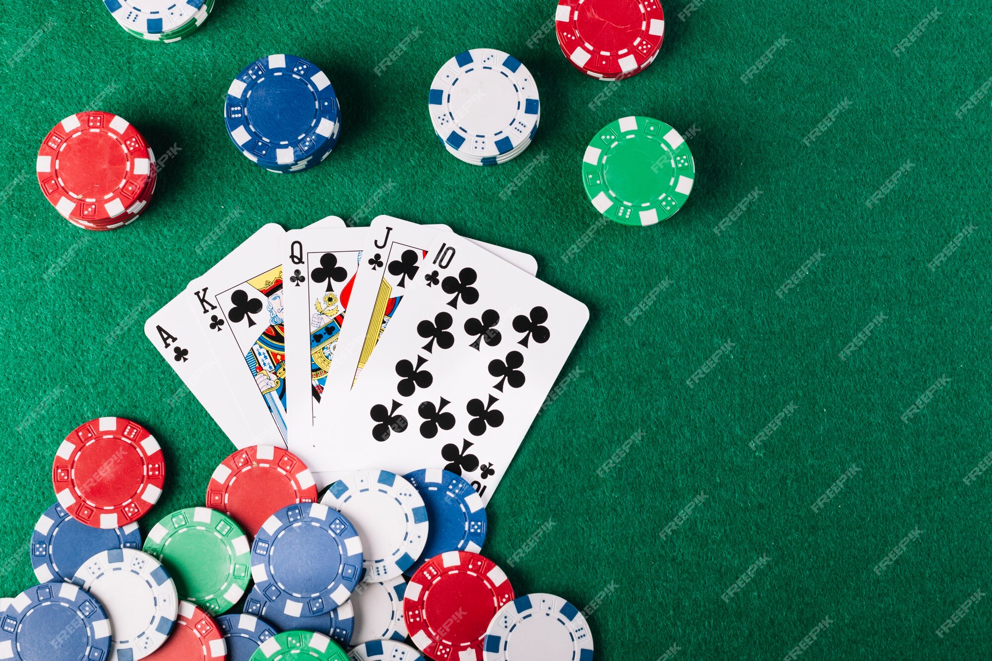 Pilha de fichas de cassino e royal flush baralho na mesa de poker verde