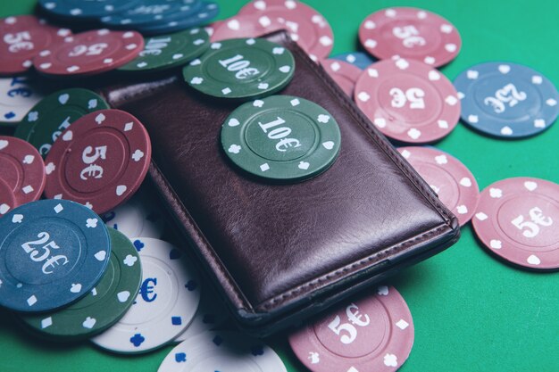 Fichas de póquer y billetera en una mesa de juego en un casino