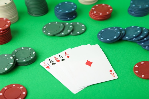 Fichas de póquer en una mesa de póquer en el casino. Poker en pared verde