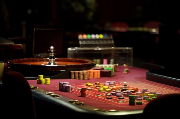 Fichas de primer plano y ruleta en el casino en la mesa roja