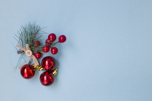 Fichtenzweig mit Ebereschenbeeren auf blauem Grund. Landschaft für die Weihnachtsfeiertage.