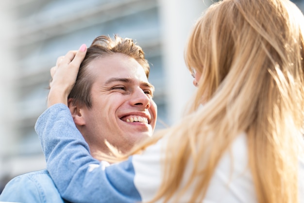 Fico feliz em passar um tempo juntos. Retrato de moda ao ar livre do jovem casal lindo. Garoto atraente e garota se abraçando e beijando.