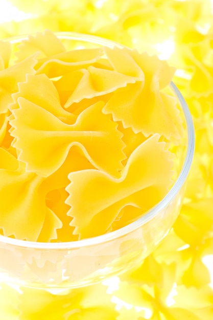 Fideos amarillos en un vaso sobre un fondo amarillo pasta