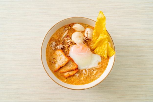 Fideos de arroz con albóndigas de cerdo asado y huevo en sopa picante