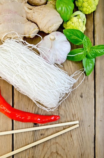 Fideos de arroz blanco fino con brócoli en el tablero