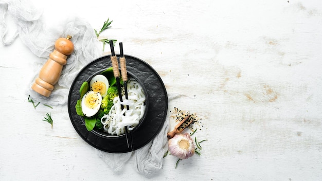 Fideos de arroz con brócoli de huevo y espinacas Cocina asiática Vista superior Espacio libre para el texto