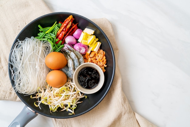 fideos de arroz con ingredientes en sartén