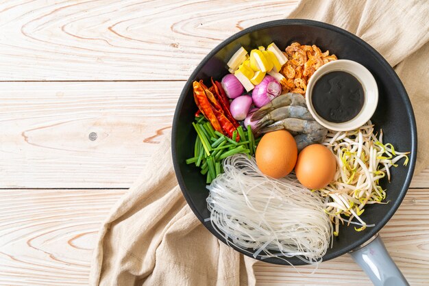 fideos de arroz con ingredientes en sartén