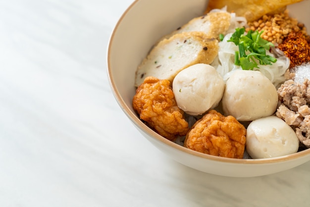 Fideos de arroz planos pequeños picantes con bolas de pescado y bolas de camarones sin sopa - estilo de comida asiática